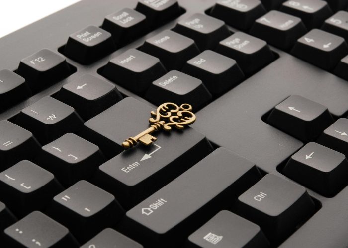 Close-up of an ornate vintage key placed on a modern computer keyboard.